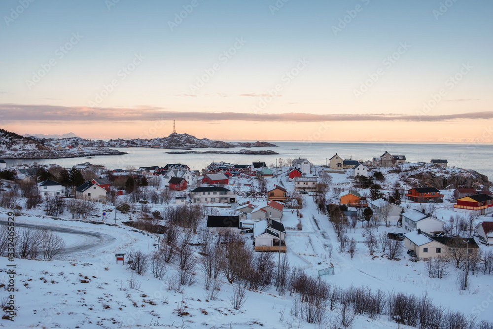 Colorful Norwegian village with snow covered on coastline in winter at boundary of Lofoten islands
