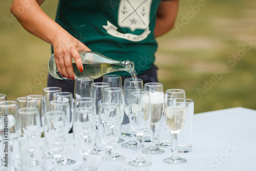 Принти на полотні the waiter pours champagne in glasses on the street - wedding catering