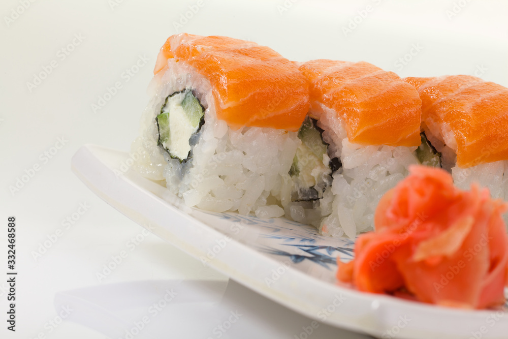 Japanese Cuisine - Appetizing Salmon Sushi Set. Philadelphia Sushi Roll - Maki Sushi with Philadelphia Cheese inside on mirror black background. Smoked salmon rolls served on a plate Japanese Cuisine - Appetizing Salmon Sushi Set. Philadelphia Sushi Roll - Maki Sushi with Philadelphia Cheese inside on mirror black background. Smoked salmon rolls served on a plate