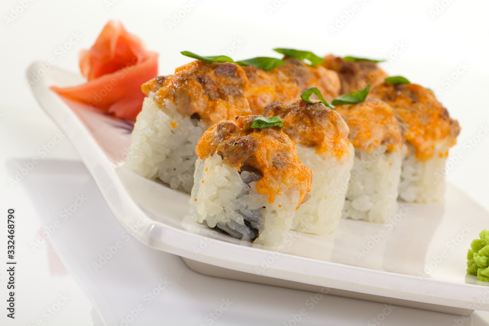 Japanese Cuisine - Appetizing Salmon Sushi Set. Philadelphia Sushi Roll - Maki Sushi with Philadelphia Cheese inside on mirror black background. Smoked salmon rolls served on a plate