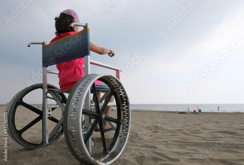 girl in a wheelchair points to the sea