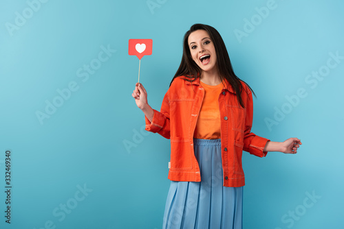 shocked woman holding stick with paper like on blue background