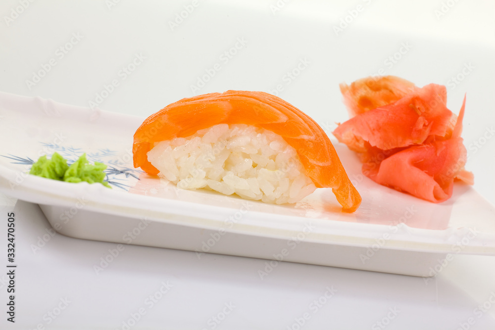 Japanese Cuisine - Appetizing Salmon Sushi Set. Philadelphia Sushi Roll - Maki Sushi with Philadelphia Cheese inside on mirror black background. Smoked salmon rolls served on a plate Japanese Cuisine - Appetizing Salmon Sushi Set. Philadelphia Sushi Roll - Maki Sushi with Philadelphia Cheese inside on mirror black background. Smoked salmon rolls served on a plate