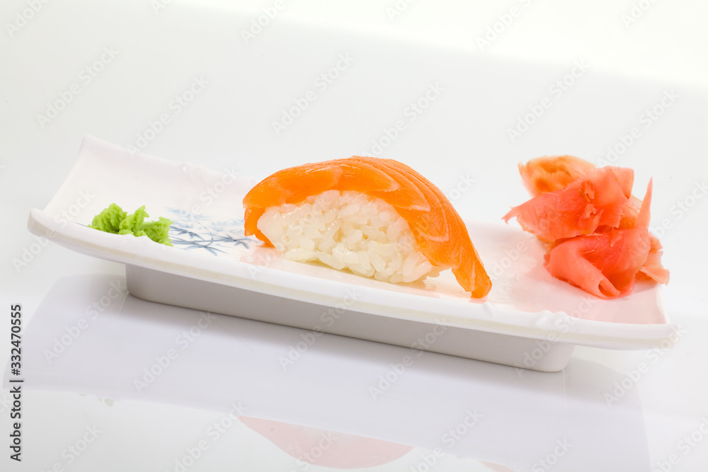 Japanese Cuisine - Appetizing Salmon Sushi Set. Philadelphia Sushi Roll - Maki Sushi with Philadelphia Cheese inside on mirror black background. Smoked salmon rolls served on a plate Japanese Cuisine - Appetizing Salmon Sushi Set. Philadelphia Sushi Roll - Maki Sushi with Philadelphia Cheese inside on mirror black background. Smoked salmon rolls served on a plate