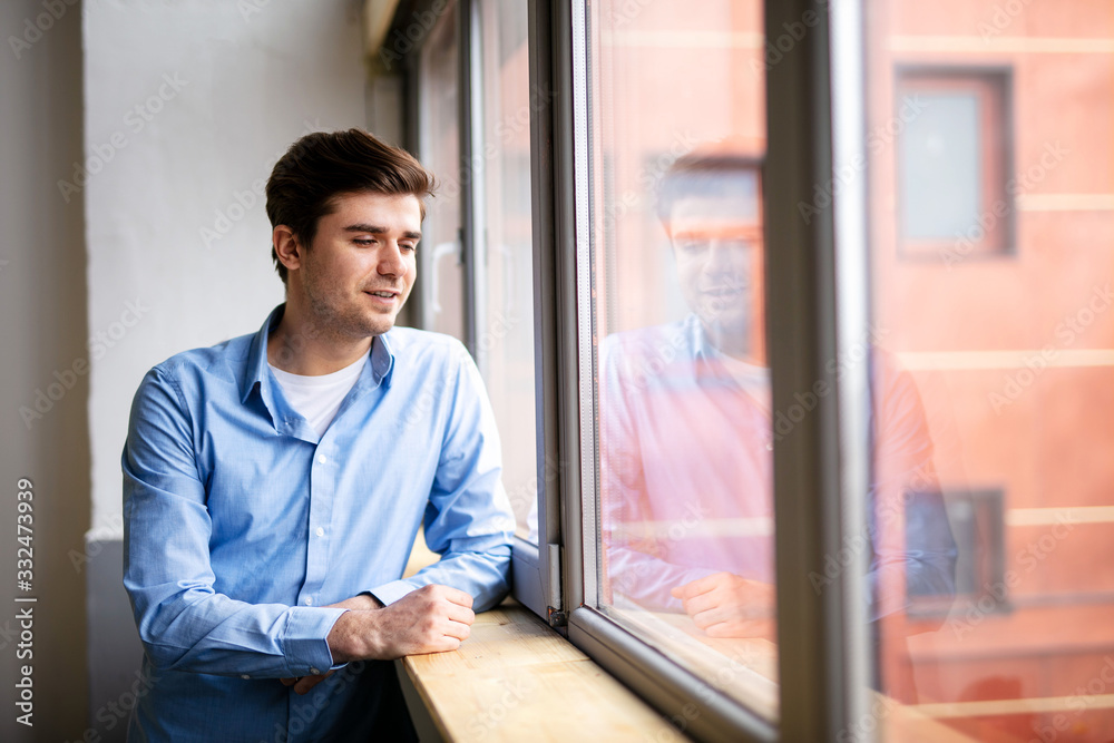 young man next to a window