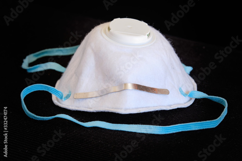 Used white  breathing mask lying isolated on black background. Seen in Germany in March.