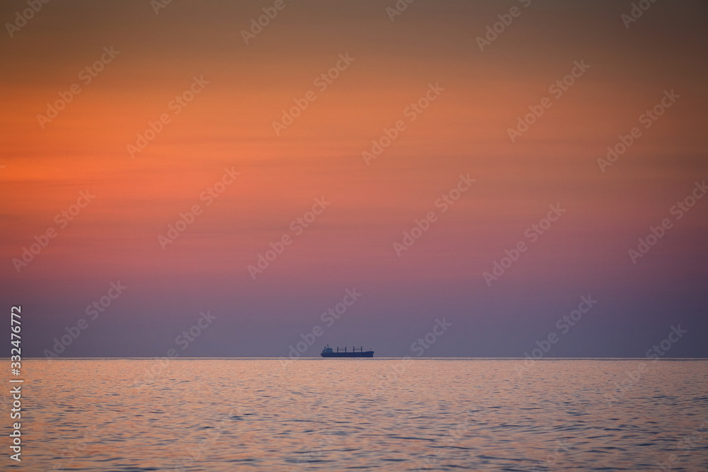 Beautiful dawn sunrise at sea with Ship silhouette