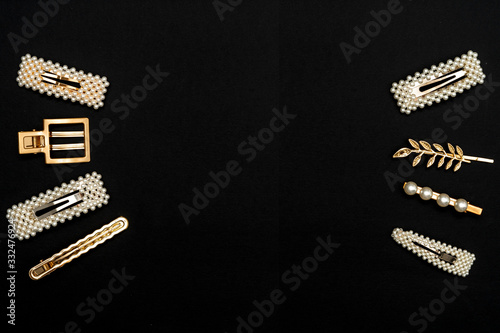 Pin set beauty trendy accessories hair pearl clip on black background. Top view. Copy space fot text.