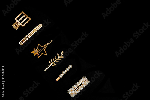 Pin set beauty trendy accessories hair pearl clip on black background. Top view. Copy space fot text.