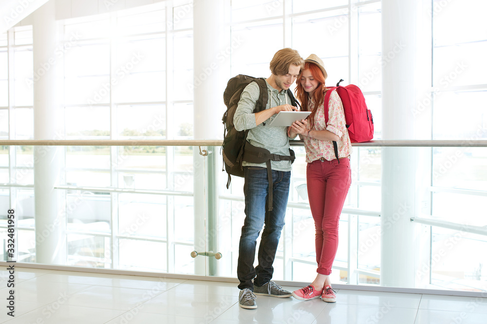 Young couple using digital tablet at airport. Young couple using digital tablet at airport.