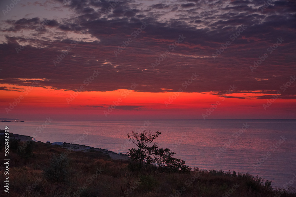 Beautiful red dawn on the coast of the sea. Seascape.