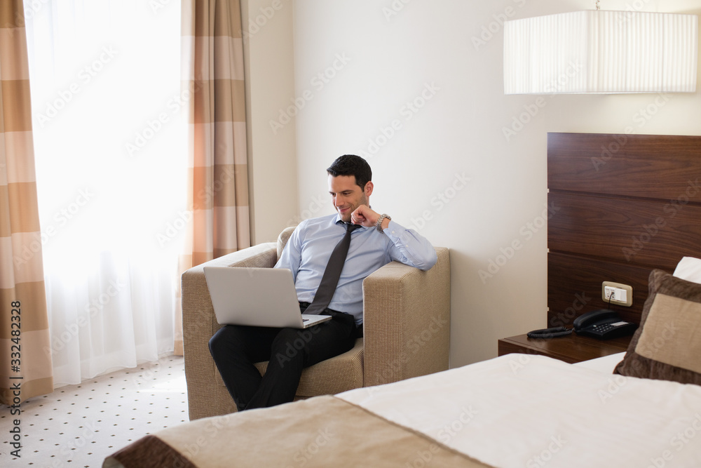 Business man using laptop in hotel room. Business man using laptop in hotel room.