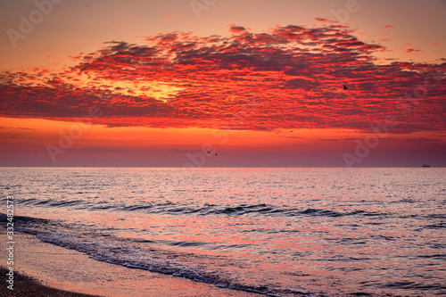 Beautiful red dawn on the coast of the sea. Seascape.