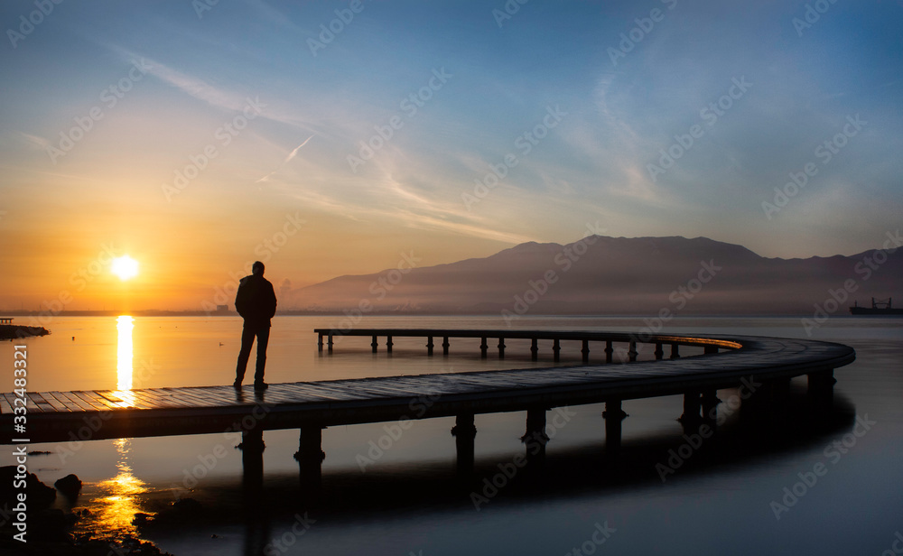 silhouette of man on the pier at sunset