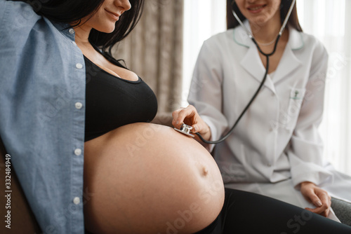 Pregnant woman with belly and a therapist at home