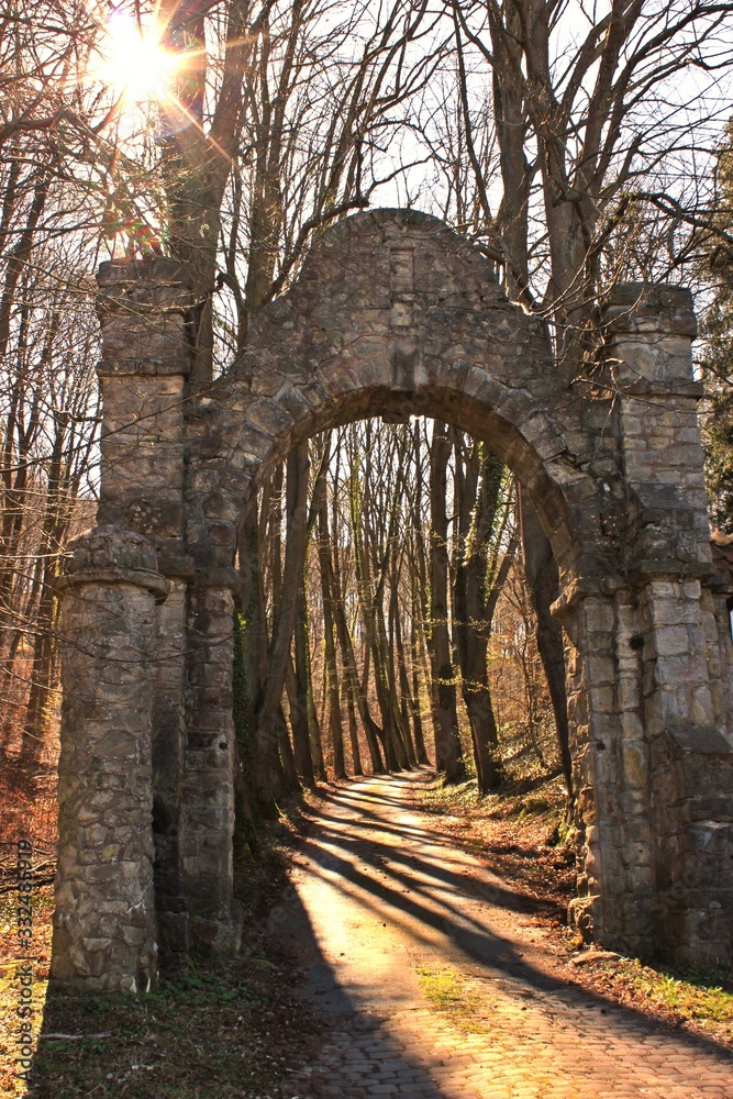 Alter gemauerter Torbogen mit Waldweg im Licht. Alter gemauerter Torbogen mit Waldweg im Licht.