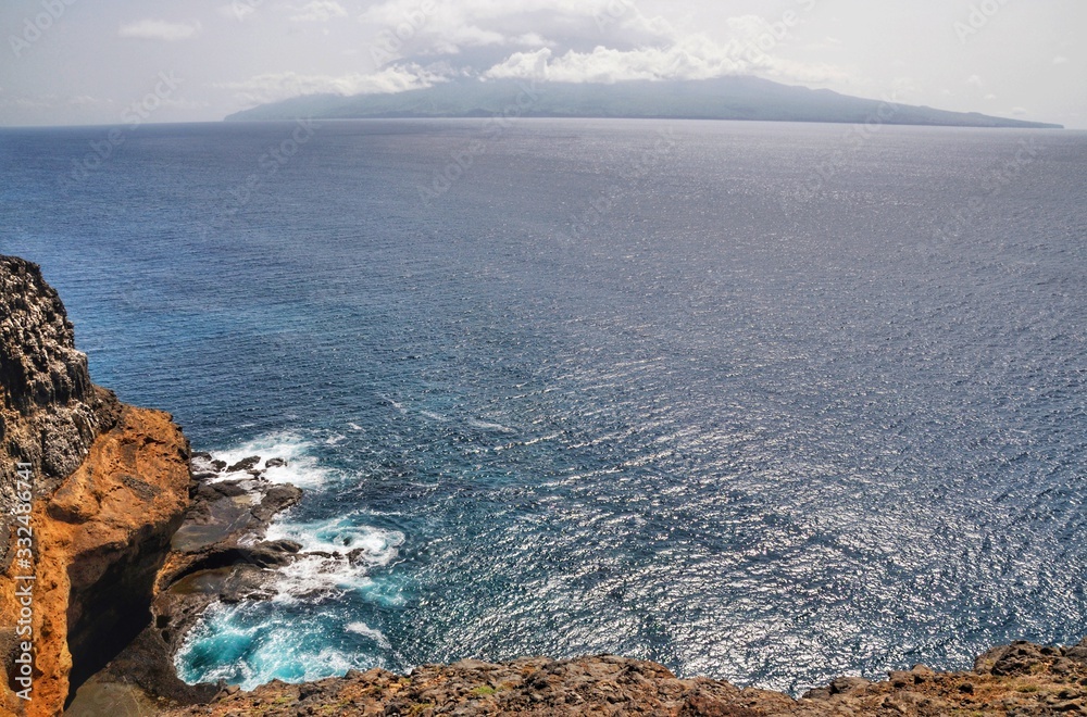 Island of Brava with clouds hovering over as seen from the islet of Djeu Island of Brava with clouds hovering over as seen from the islet of Djeu