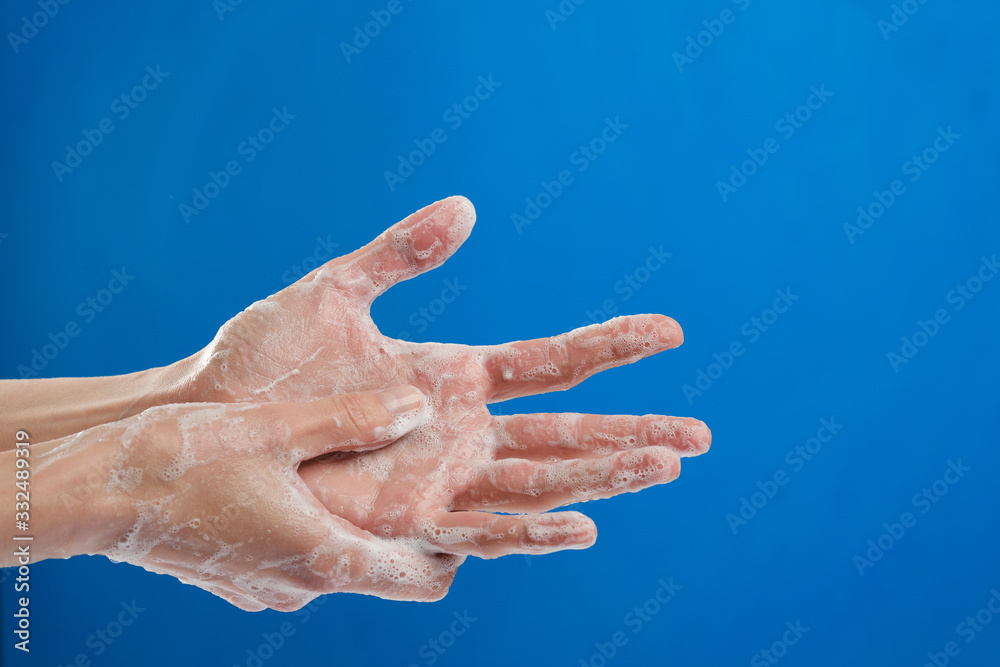 tutorial, woman wash hands with soap, closeup on blue background. Hygiene tutorial, woman wash hands with soap, closeup on blue background. Hygiene