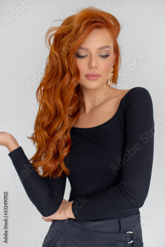 Young beautiful redhead girl in black clothes.