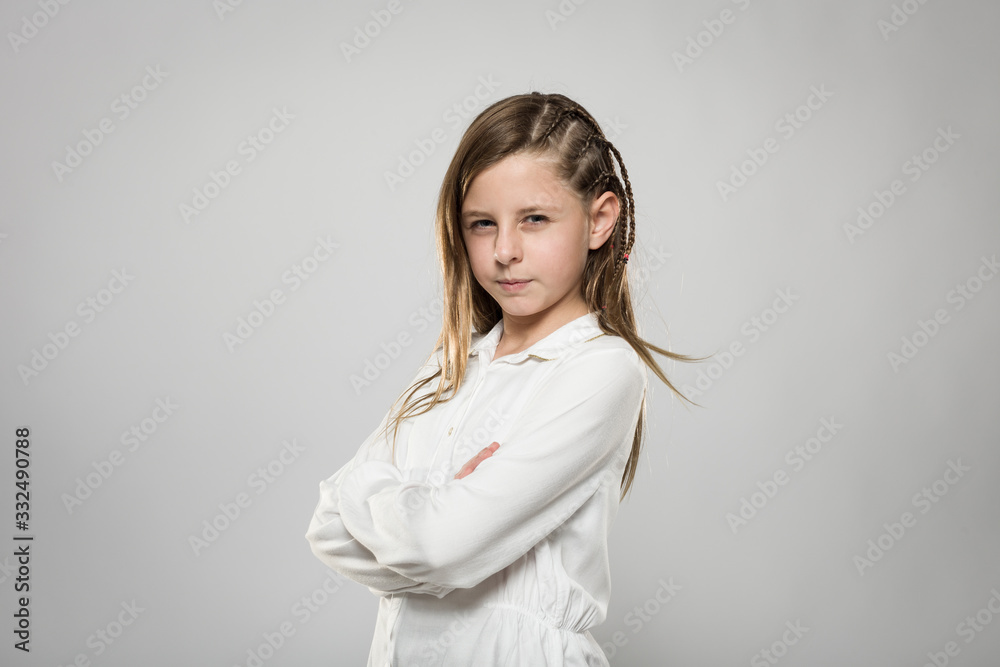 Studio portrait of a cute angry girl with long blonde hair wearing a white shirt against neutral background Studio portrait of a cute angry girl with long blonde hair wearing a white shirt against neutral background