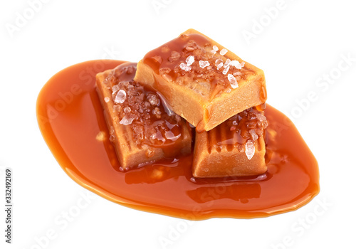 Delicious candies with caramel sauce and salt on a white background