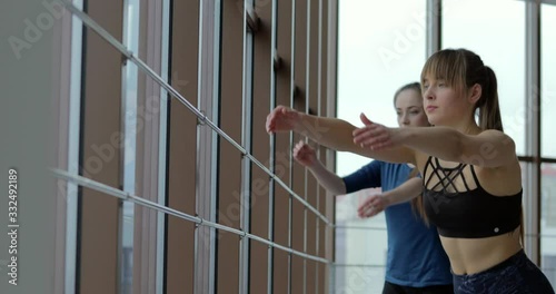 girls practice yoga in a large, light room. coach and student. sport training concept.