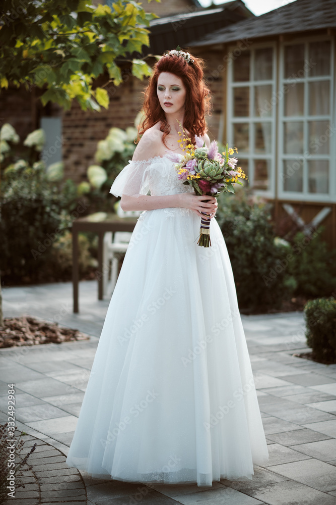 Young bride wearing wedding dress and posing outside Young bride wearing wedding dress and posing outside