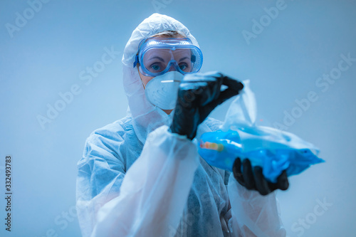 Medical doctor, scientist in full body suit for prevention from viruses and diseases holding a antiseptic tissue for disinfection.