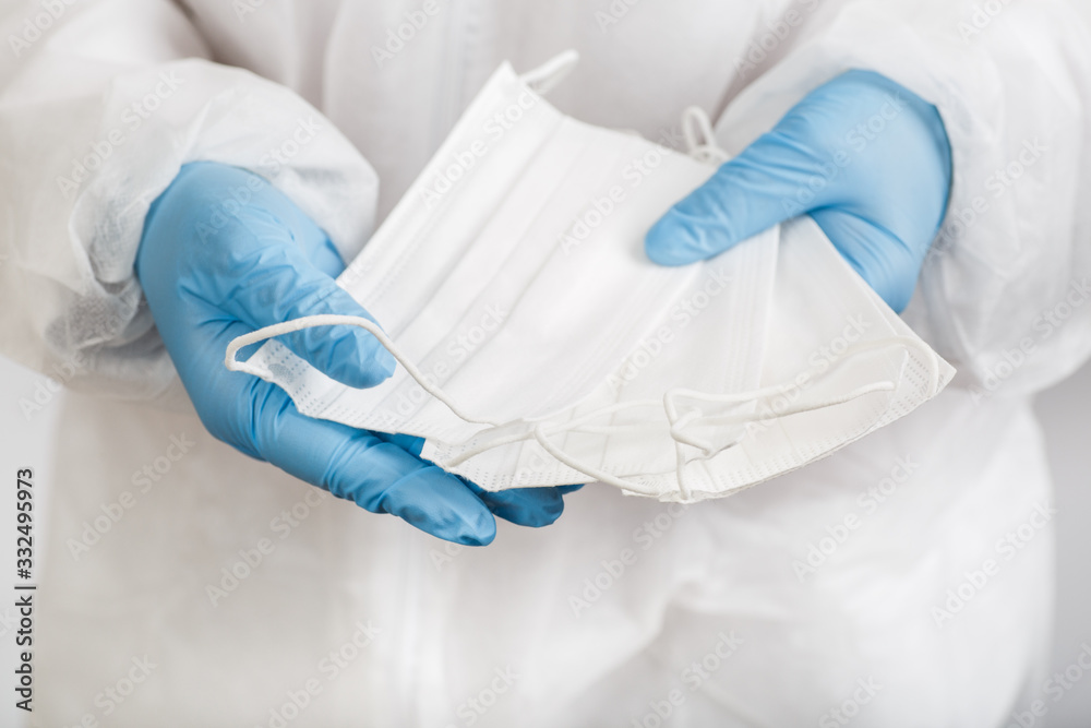Fototapeta premium Doctor's hand with some medical face mask for protection against infection