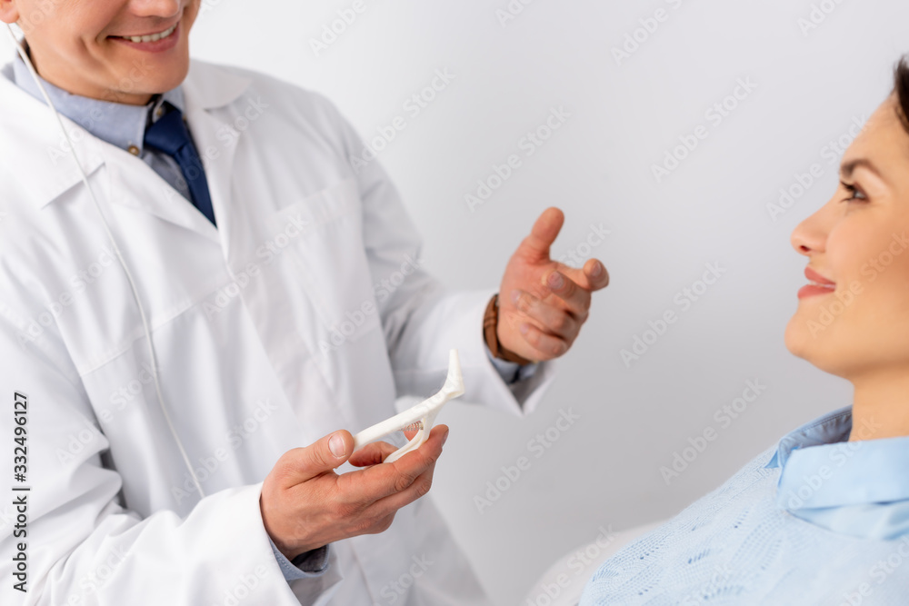 cropped view of smiling ent physician holding nasal speculum near attractive patient cropped view of smiling ent physician holding nasal speculum near attractive patient