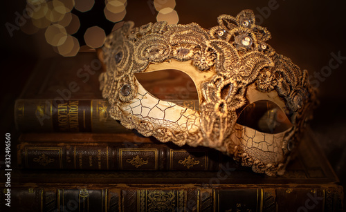 A vintage stack of an old brown leather books with venetian mask