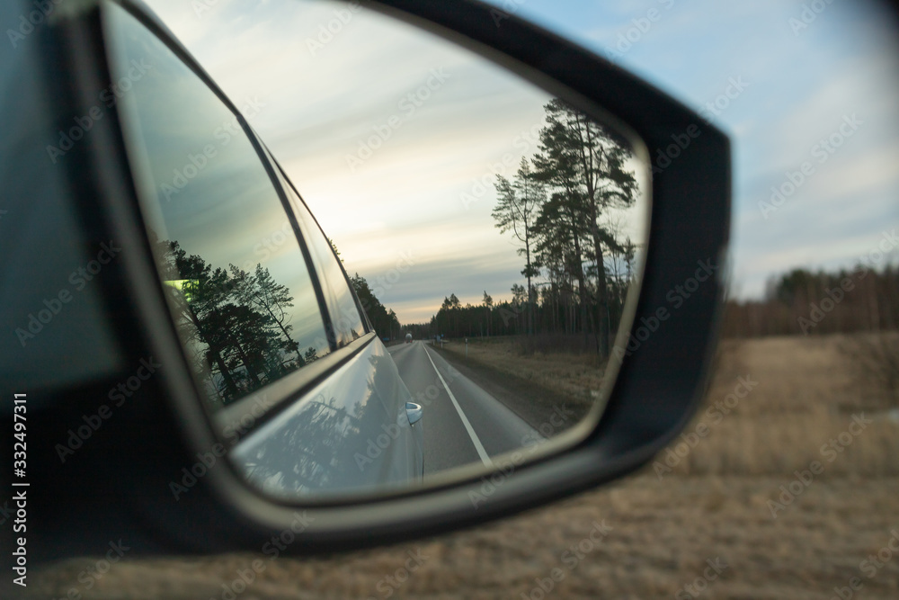 Reflection of the highway in a car mirror. Toned photo. Road travel concept.Driving car in sunset.Beauty on sky going on trip at night.reflection of the road in the sunset sunlight blurry