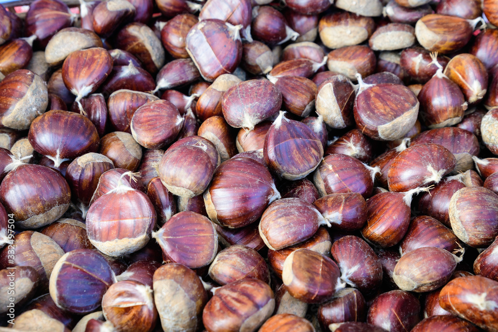 Fall and winter rustic dessert sweet roasted chestnuts in a large metallic bowl, available for sale at a street food market festival, seasonal food photograph with selective focus Fall and winter rustic dessert sweet roasted chestnuts in a large metallic bowl, available for sale at a street food market festival, seasonal food photograph with selective focus
