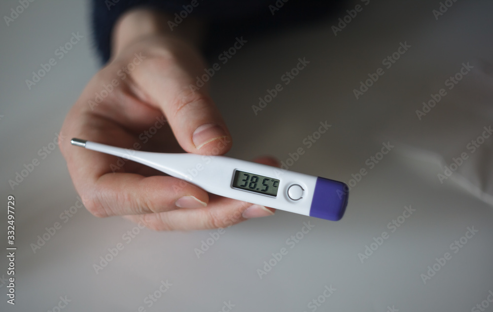 Man holding thermometer with 38.5 degrees. High temperature. Close up Man holding thermometer with 38.5 degrees. High temperature. Close up