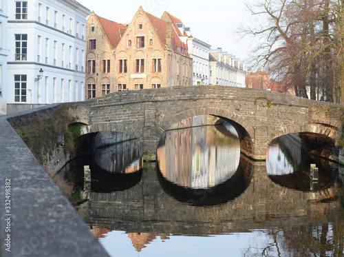 View on the Augustijnenbridge in Bruges, with reflection in the water on a late afternoon in the end of winter photo