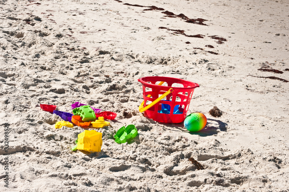 Front, top view of a Childs plastic beach toys on a sandy, tropical beach on gulf of mexico, on sunny day Front, top view of a Childs plastic beach toys on a sandy, tropical beach on gulf of mexico, on sunny day