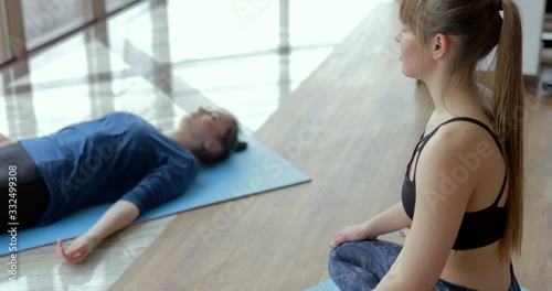 girls practice yoga in a large, light room. coach and student. sport training concept.