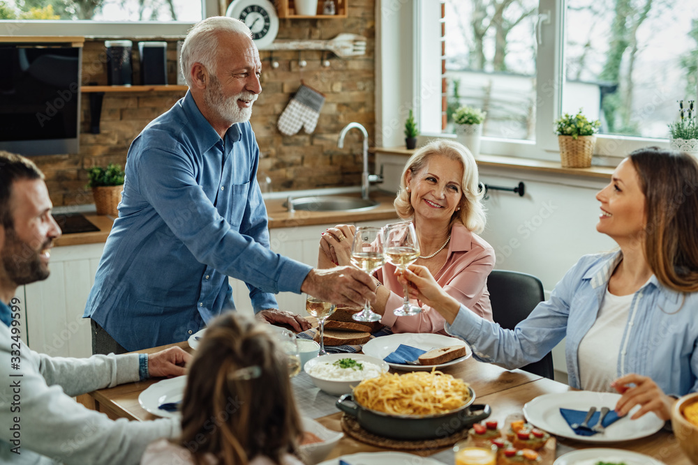 Happy extended family enjoying in a lunch and toasting at dining table. Happy extended family enjoying in a lunch and toasting at dining table.