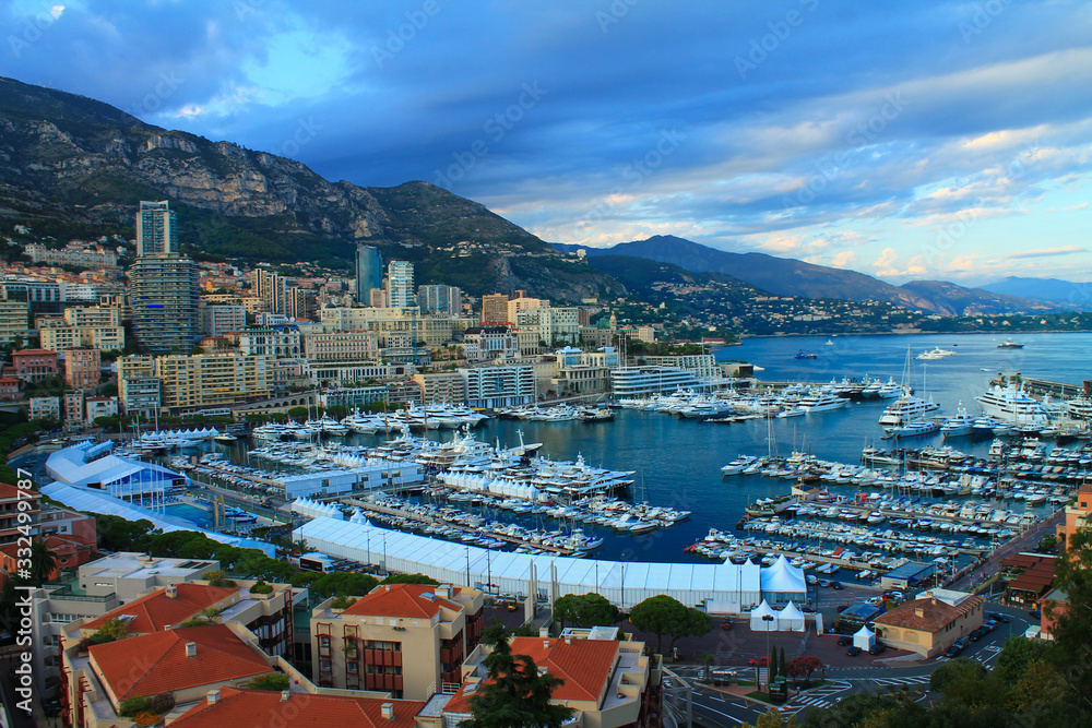 Principality of Monaco. Beautiful panoramic view of Monaco, golden hour scenery. View of residential buildings and a large port with luxury yachts.