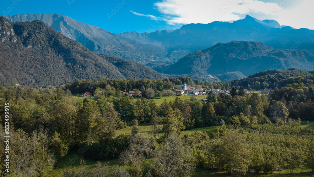 Valley of Kobarid in early morning with Svino village in the foreground. Beautiful green autumn panorama of villages along Soca river in Slovenia