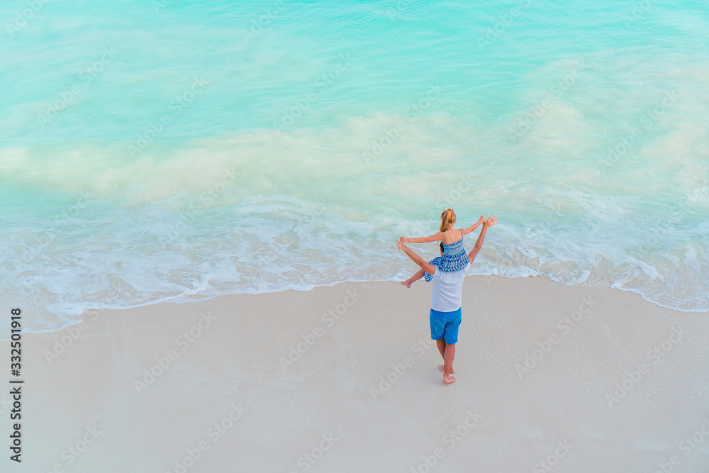 Little girl and happy dad having fun during beach vacation