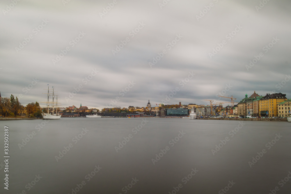 Paorama of sailboat of Af Chapman in Stockholm and other ships in front of Gamla stan and Katarina - Sofia area in the background on a cloudy rainy autumn day.