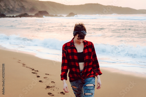 Woman walking on wet sand on beach photo