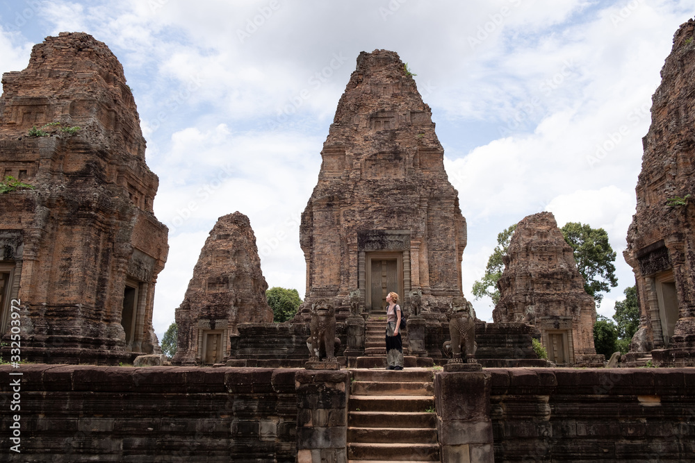 Side view of unrecognizable woman looking at ancient ruins of religious Hindu temple of Angkor Wat in Cambodia Side view of unrecognizable woman looking at ancient ruins of religious Hindu temple of Angkor Wat in Cambodia