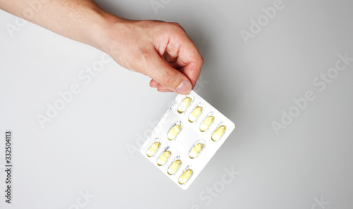 blister capsule in hand on a light background