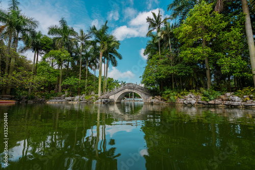 Stone oriental bridge on tropical park photo