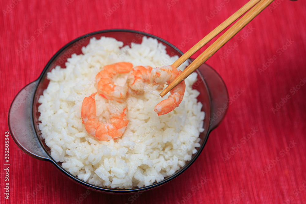 Shrimp with rice in a brown plate with chopsticks, sharpness in the foreground. Shrimp with rice in a brown plate with chopsticks, sharpness in the foreground.