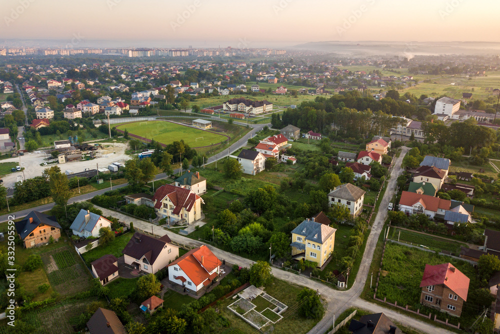 Aerial landscape of small town or village with rows of residential homes and green trees.