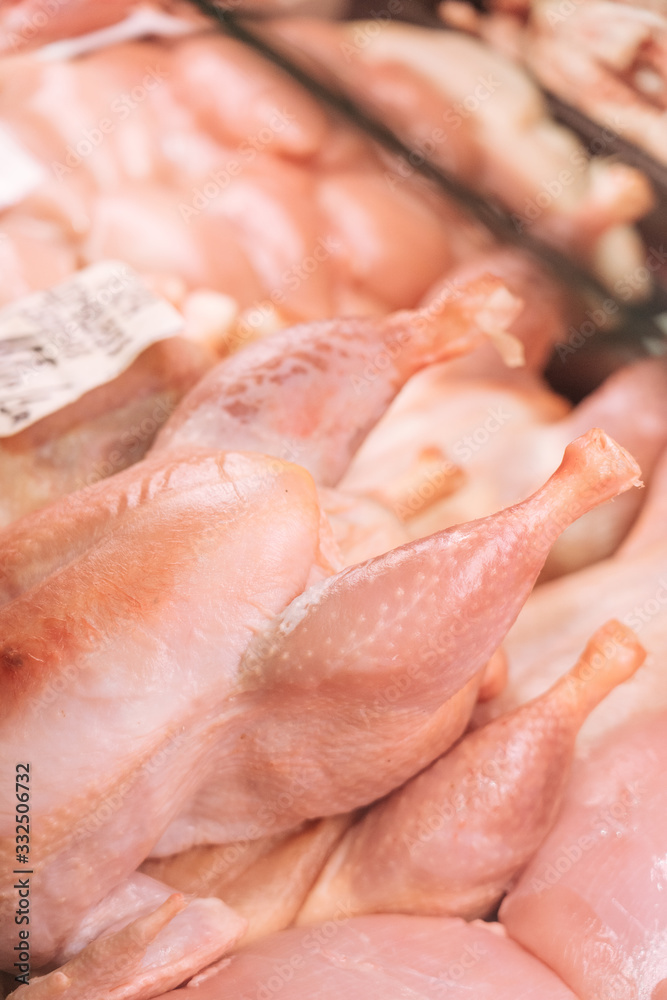 From above heap of uncooked chicken meat placed inside refrigerator in grocery store From above heap of uncooked chicken meat placed inside refrigerator in grocery store
