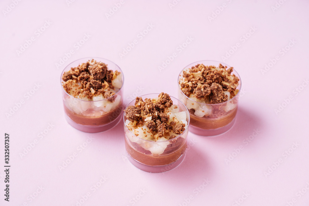 From above glass cups with delectable chocolate mousse placed on pink background From above glass cups with delectable chocolate mousse placed on pink background